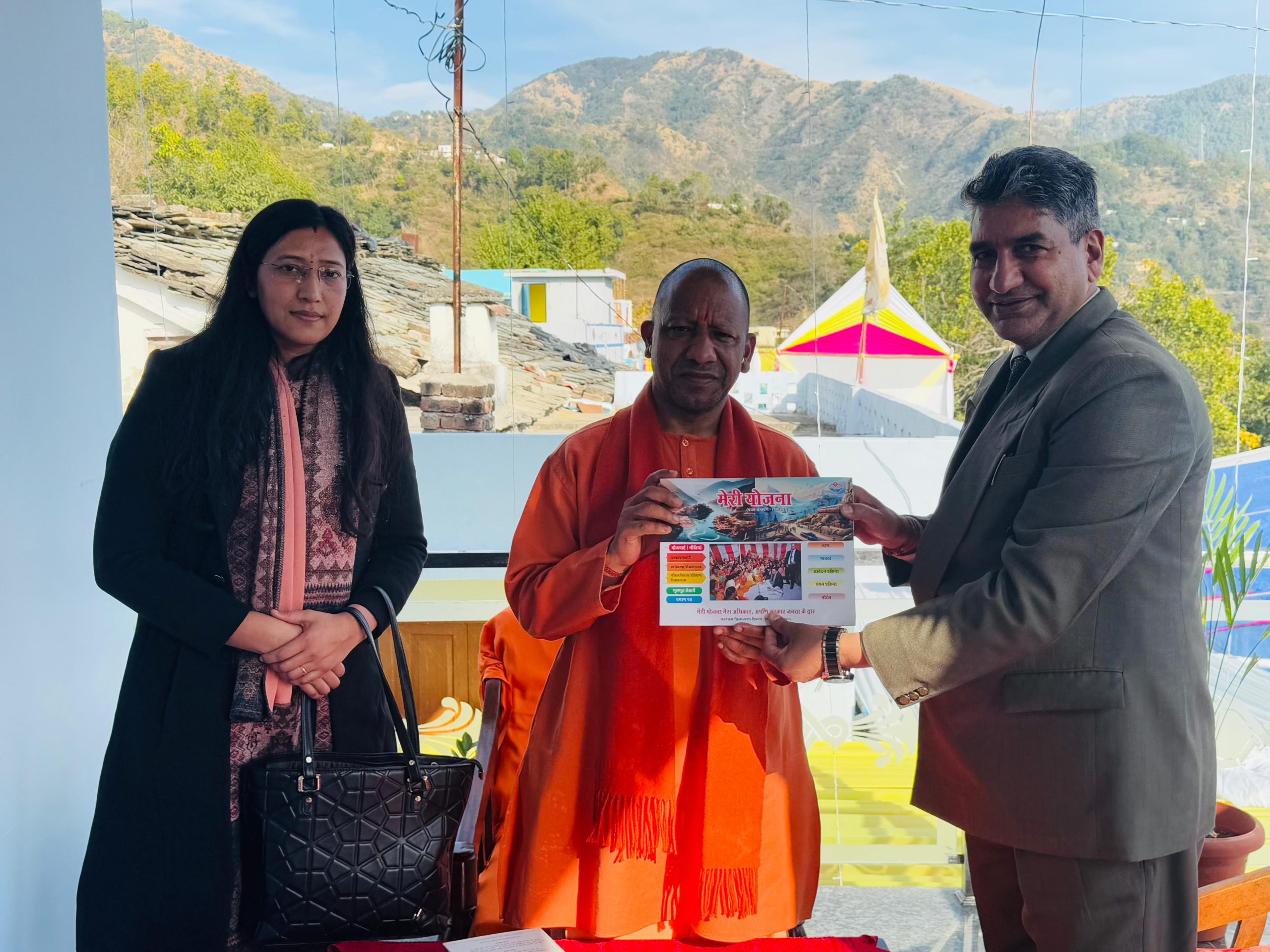 CM Yogi Adityanath Receives Meri Yojana Book from uttarakhand sarkar